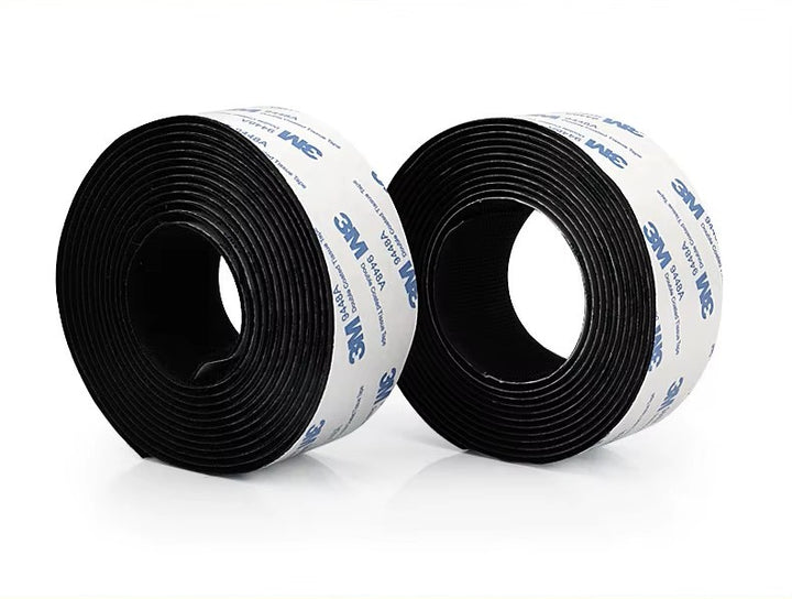Two rolls of 3M black Velcro tape on a white background