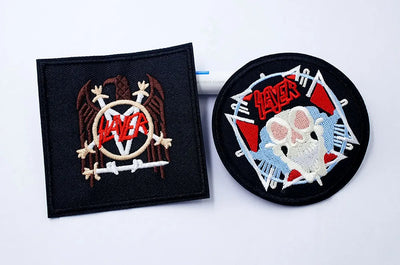 Two Slayer patches, one square and one round, on a white background