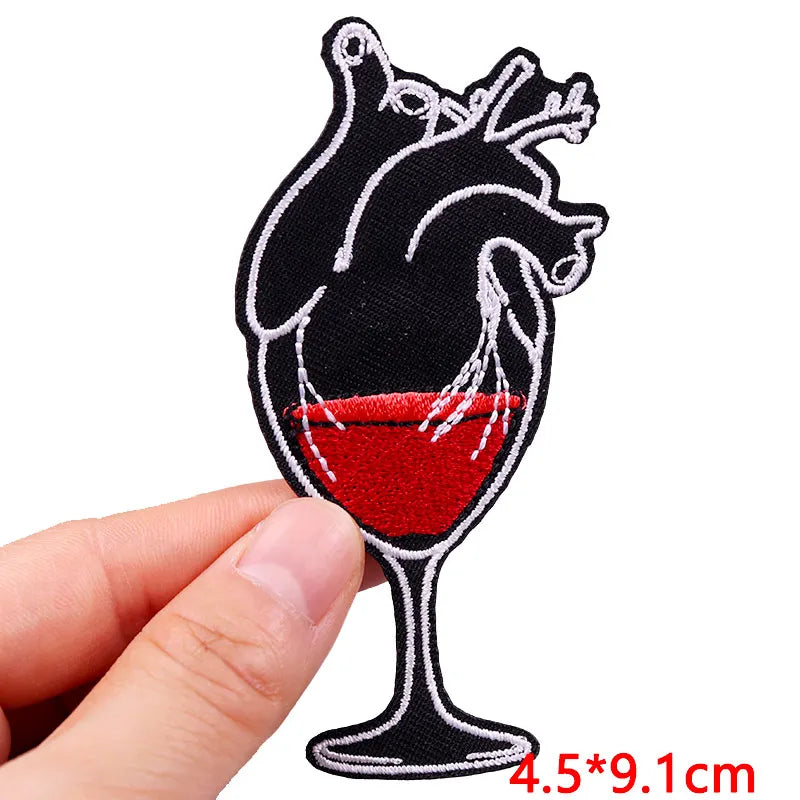 Heart-shaped wine glass patch held by a hand with dimensions displayed.