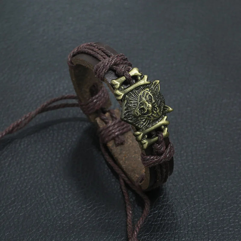 Brown leather bracelet with a bronze lion head emblem on a dark gray background