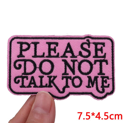 Pink patch with black text 'PLEASE DO NOT TALK TO ME' held by a hand, with dimensions displayed.