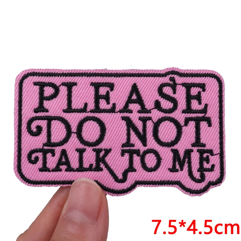 Pink patch with black text 'PLEASE DO NOT TALK TO ME' held by a hand, with dimensions displayed.