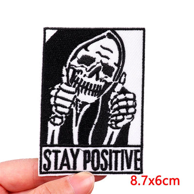 Patch with skeleton design and 'Stay Positive' text held by a hand, with dimensions displayed.