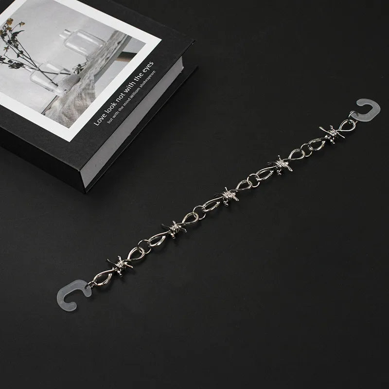 Silver chain for crocs on a black surface with a decorative box in the background