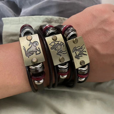 Bracelet with metal clasps and animal emblem on wrist against a neutral background