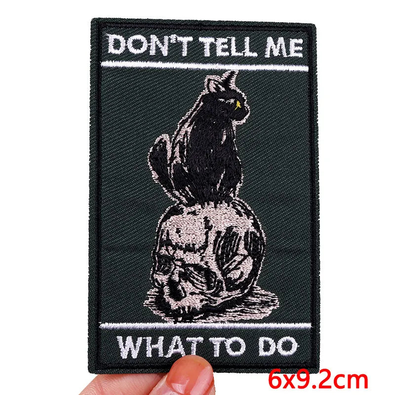 Patch with a black cat on a skull and text &