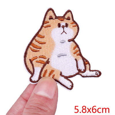 Cat-shaped patch held between a finger and thumb with size '5.8x6cm' displayed.