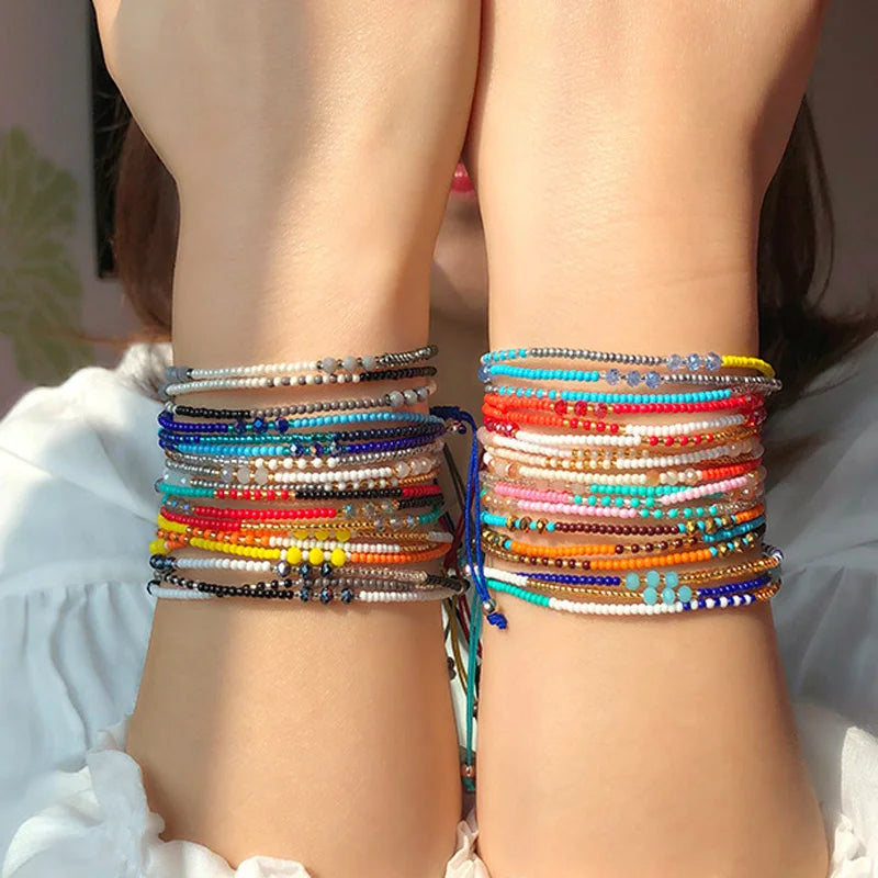 Multicolored beaded bracelets on a person's wrist with a blurred background