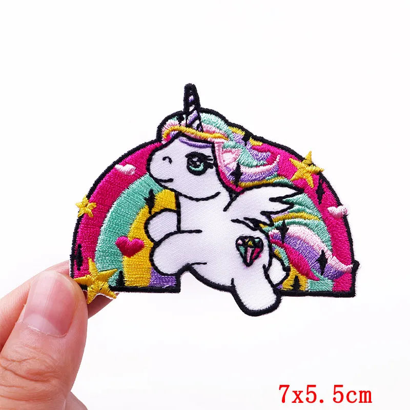 Colorful unicorn patch held by a hand with dimensions indicated.
