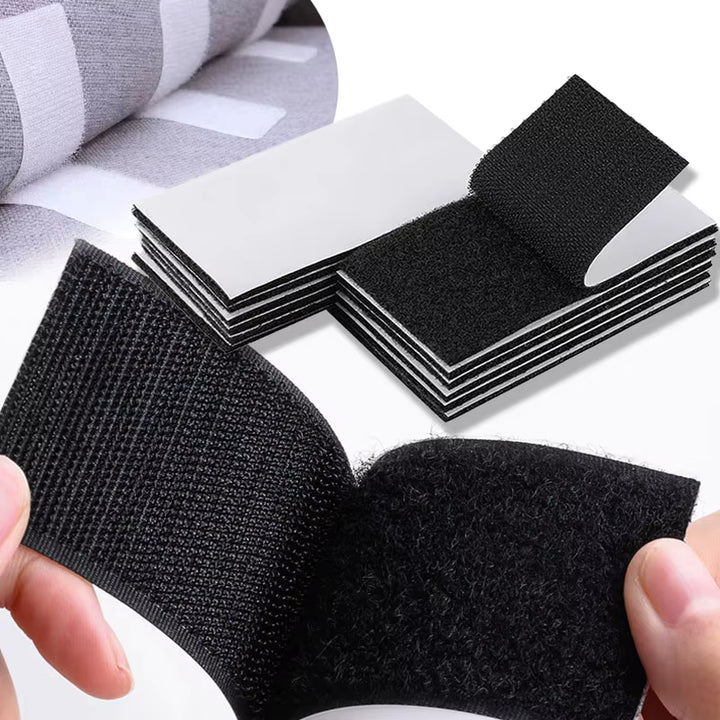 Black velcro strips on a white background with a hand holding one strip.
