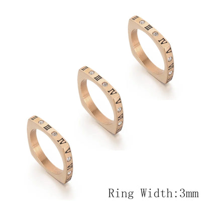 Three rose gold rings with Roman numeral detailing on a white background