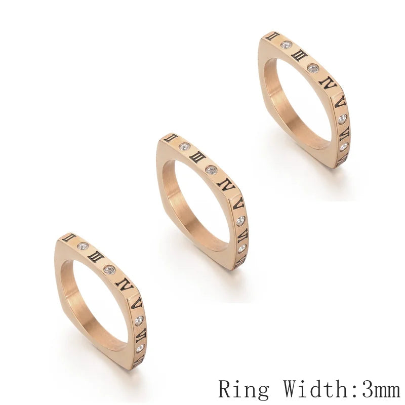 Three rose gold rings with Roman numeral detailing on a white background