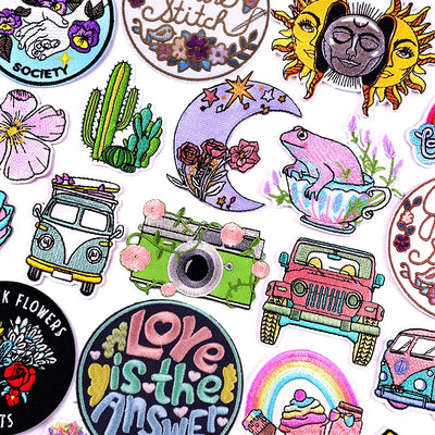 Collection of colorful embroidered patches with various designs on a white background.