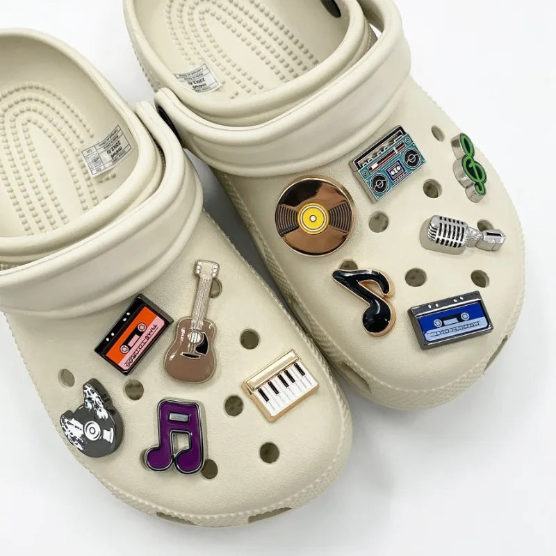 Beige clogs with decorative pins on a white background