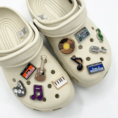Beige clogs with decorative pins on a white background