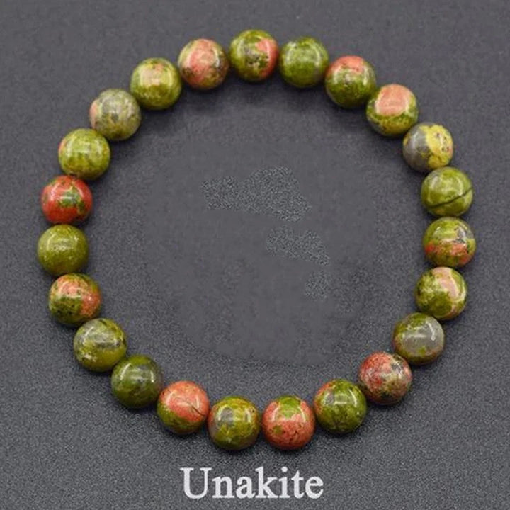 Unakite beaded bracelet on a dark gray background with &
