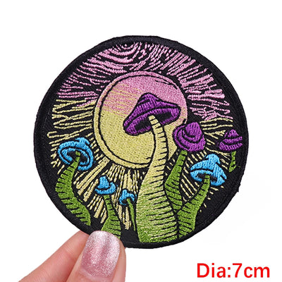Circular embroidered patch with mushrooms and flowers held by a hand, labeled 'Dia:7cm'.