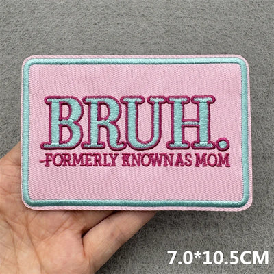 Pink patch with 'BRUH. Formerly Known As Mom' text held by a hand on a gray background