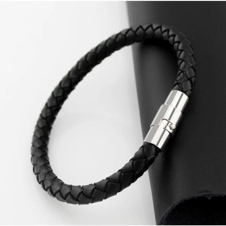 Black braided leather bracelet with a silver clasp on a white background