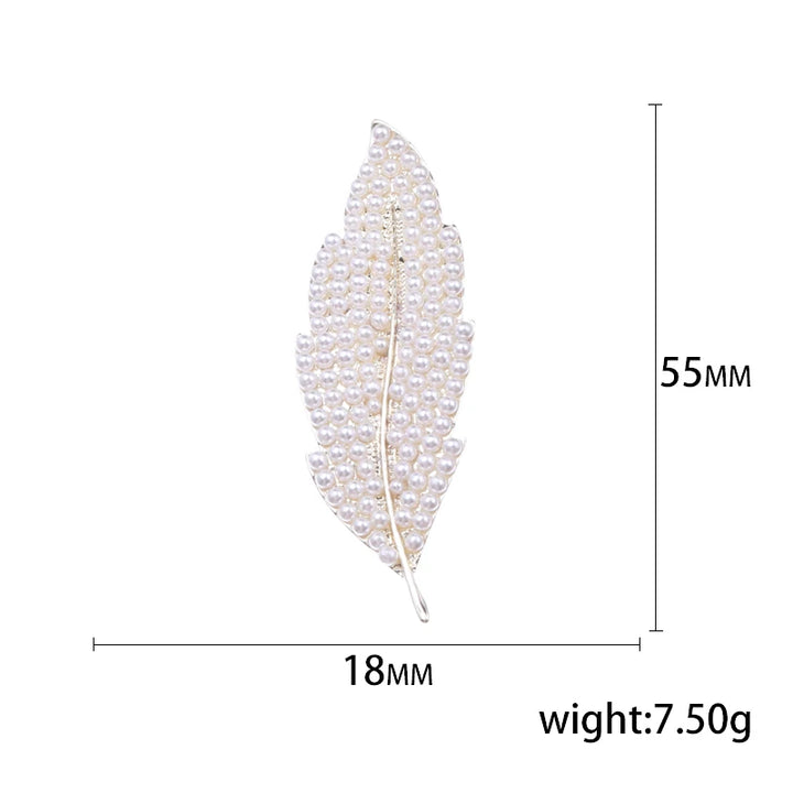 Feather-shaped brooch with measurements on a white background
