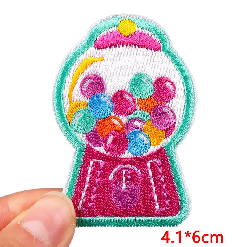 Colorful gumball machine patch held by a hand with size indication.