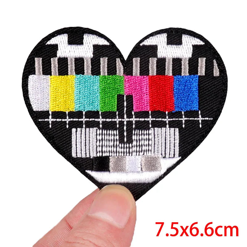Heart-shaped patch with test pattern held by a finger, size 7.5x6.6cm