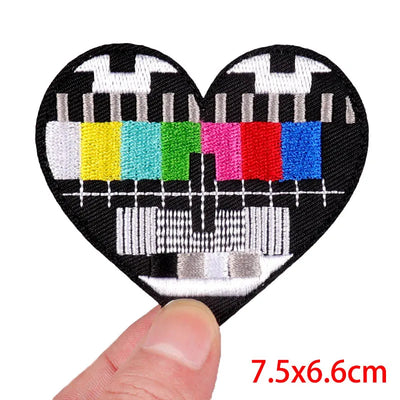 Heart-shaped patch with test pattern held by a finger, size 7.5x6.6cm