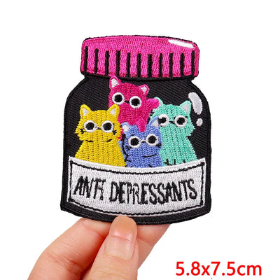 Embroidered patch of a jar labeled 'Anti Depressants' with colorful cats on a white background.