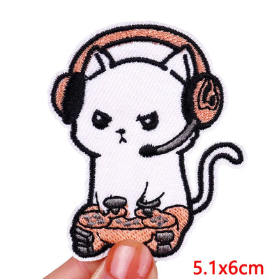 Embroidered patch of a cat with headphones and a pizza, held by a hand.