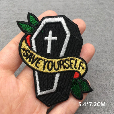Embroidered patch with 'Save Yourself' text held in a hand on a gray background