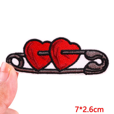 Heart-shaped patch held by a hand with measurement text on a white background