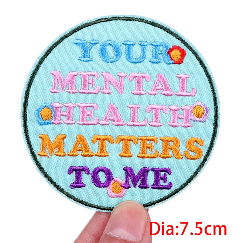 Circular patch with embroidered text 'Your Mental Health Matters to Me' held by a hand.