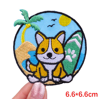 Embroidered patch of a corgi dog with a tropical background held by a hand.