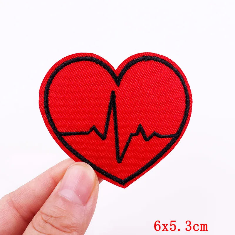 Red heart-shaped patch with an ECG line held by a hand on a white background