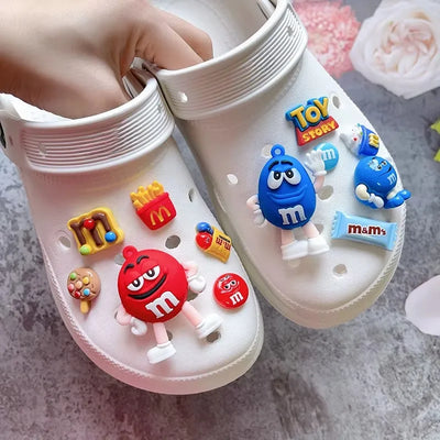 White clogs with colorful character and logo charms on a gray surface.