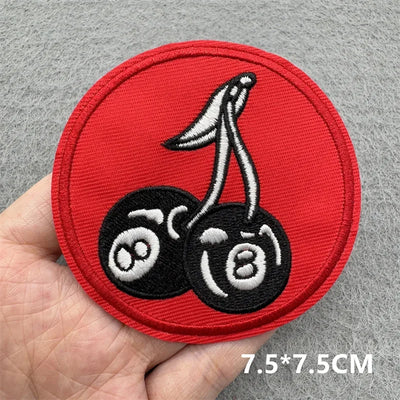 Circular patch with cherries on a red background held by a hand, with size '7.5*7.5CM' displayed.