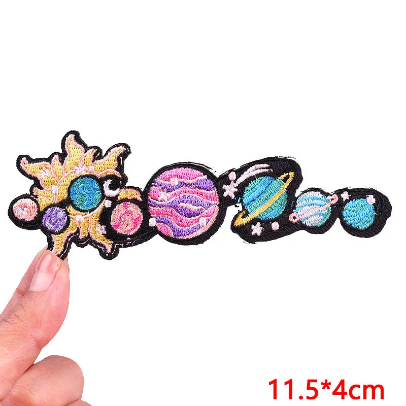 Colorful space-themed hair clip held by a hand with measurement text '11.5*4cm' on a white background.