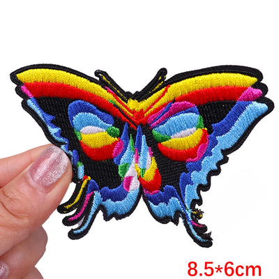 Colorful butterfly patch held by a hand with dimensions displayed.