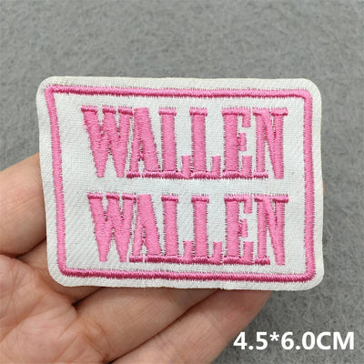 Embroidered patch with 'WALLEN' text held in hand against a gray background