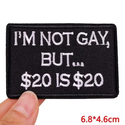 Black patch with white text held by a hand, with dimensions displayed.