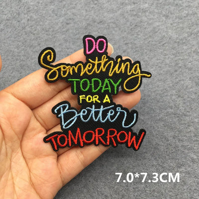 Embroidered patch with motivational quote held in hand on a gray background