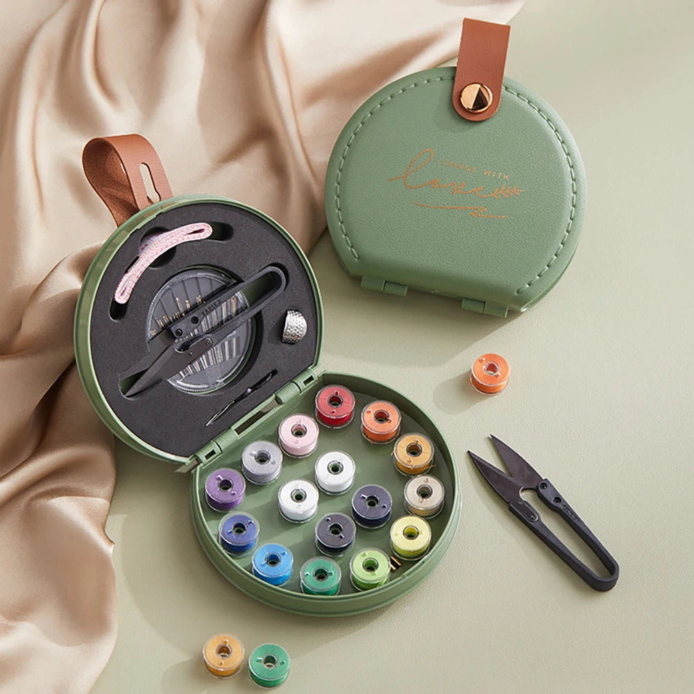 Green sewing kit with thread spools and scissors on a beige fabric background