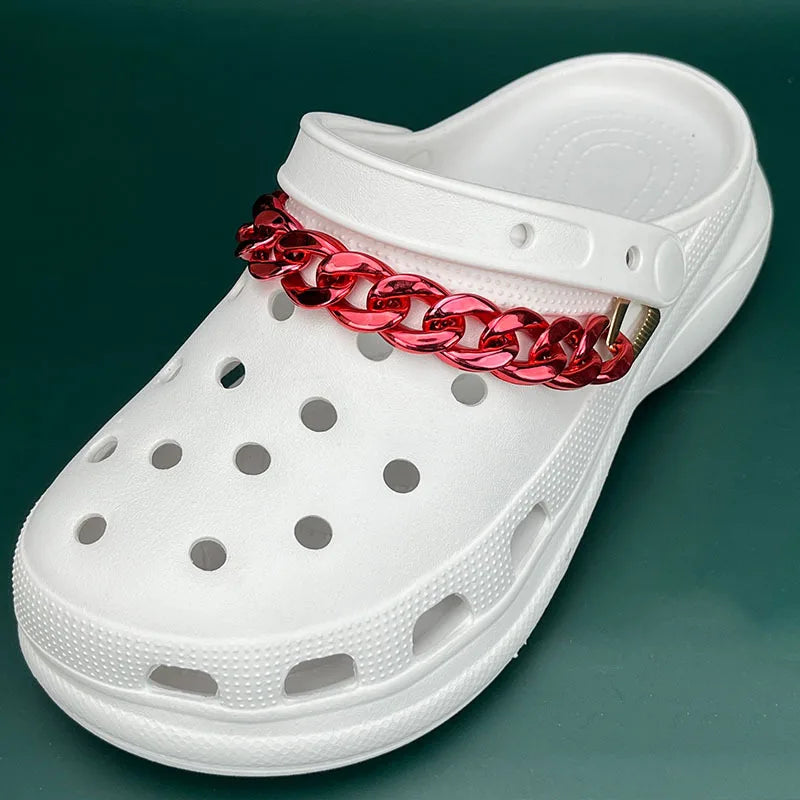 White clog shoe with a red chain around the ankle on a green background