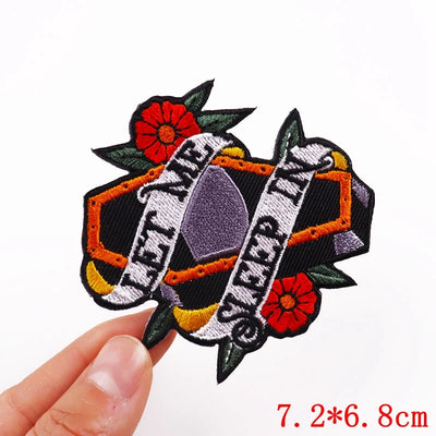 Decorative patch with floral elements held by a hand on a white background