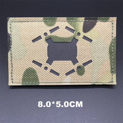 Multicam patterned card with a black symbol and measurement text on a dark background