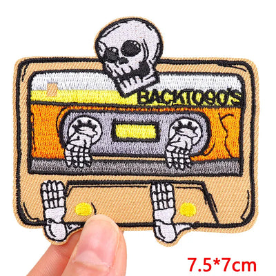 Patch with skeleton hands holding a cassette tape and skull, labeled 'Back to the 80s'.