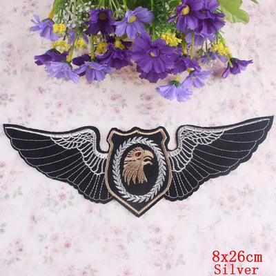 Decorative patch with wings and an eagle emblem on a floral background