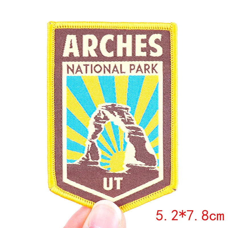 Arches National Park patch held by a hand with dimensions indicated.
