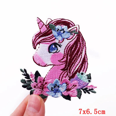 Embroidered patch of a pink unicorn with flowers on a white background