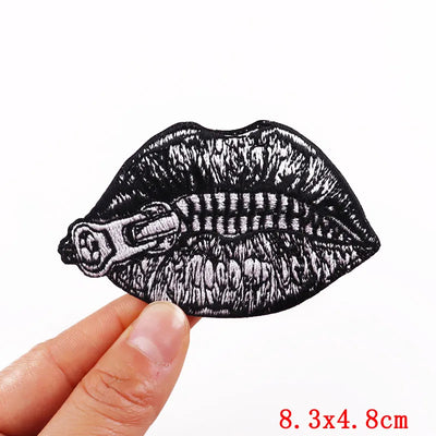 Black and white lip-shaped lipstick patch held by a hand on a white background